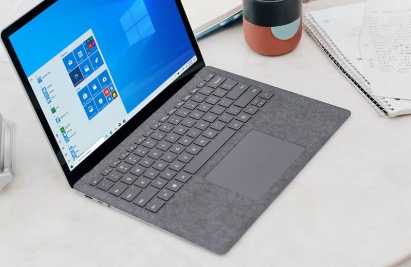 gray microsoft surface laptop computer on white table