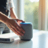 Main tenant une enceinte connectée avec lumières bleues Alexa