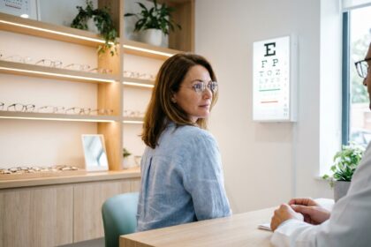 Femme d'une quarantaine d'années essayant des lunettes de vue chez un opticien lors d'un bilan visuel