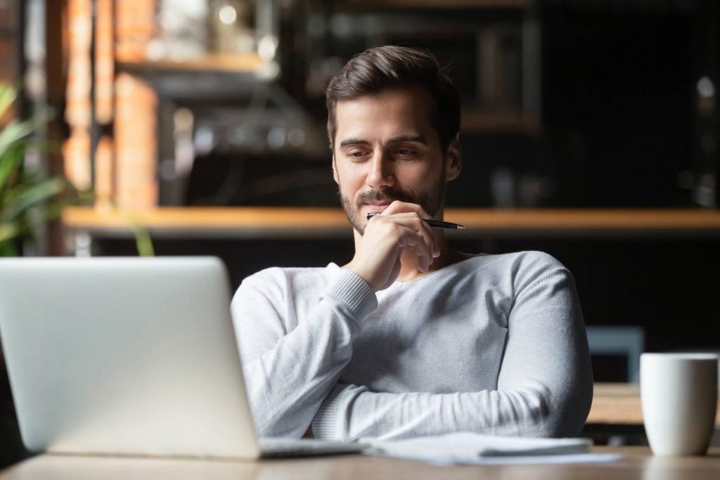 Un homme réfléchit devant son ordinateur